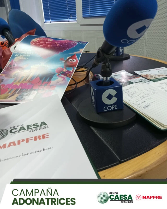 Micrófono de COPE Cartagena junto a las carpetas de Grupo Caesa Mapfre durante la entrevista