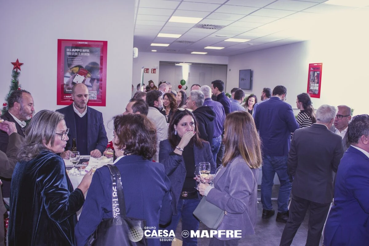 Invitados disfrutando del cóctel de inauguración en el interior de la nueva oficina