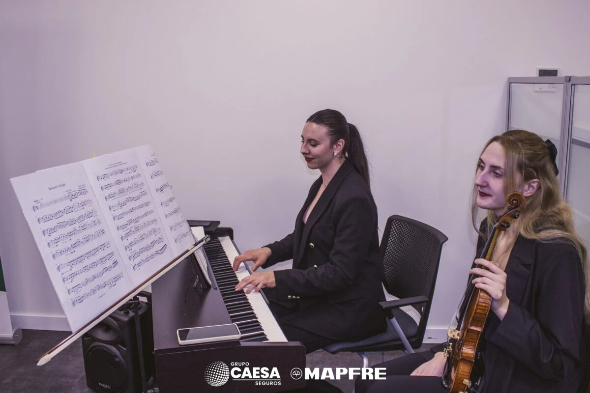 Dúo de piano y violín amenizando la inauguración de la nueva oficina